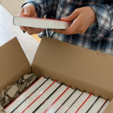 Person opening a box full of new books